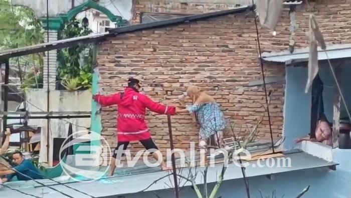 Kapolrestabes Medan Naik Atap Evakuasi Nenek yang Terjebak Banjir di Brigjen Katamso