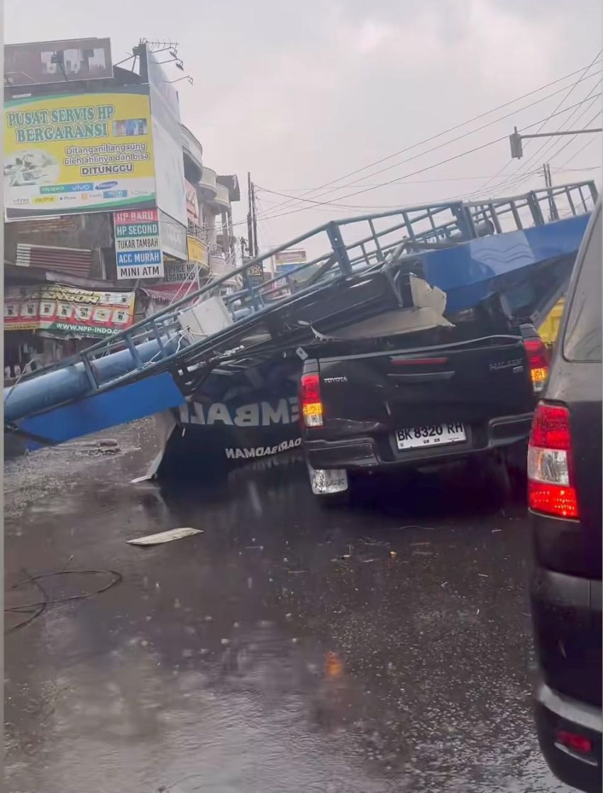 Hujan Deras Disertai Angin Kencang, Reklame Tumbang Timpa Mobil dan Motor di Pancur Batu